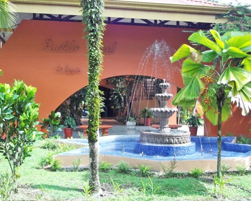 An exterior view of a fountain alongside landscaping.
