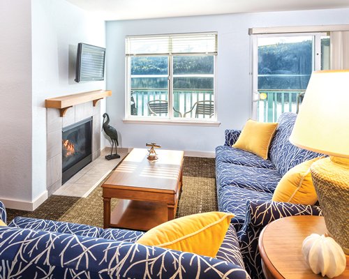 An open plan living and dining area with a pull out sofa and a television.