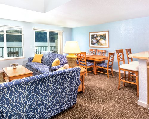A well furnished dining area with a fire in the fireplace television and patio.