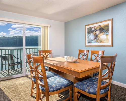 An open plan dining area and kitchen with a breakfast bar and an outside view.