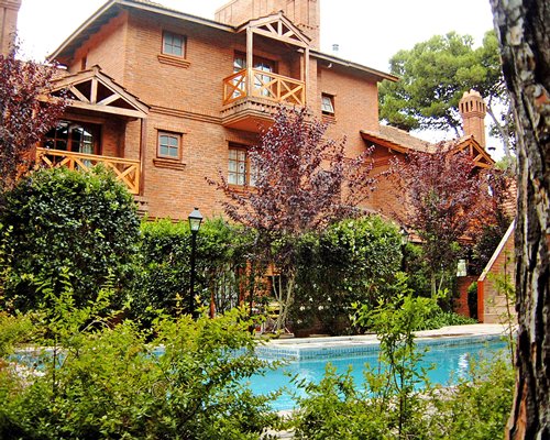Outdoor swimming pool alongside a unit with balcony.