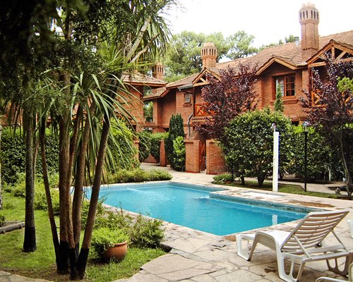 An outdoor swimming pool with chaise lounge chairs.