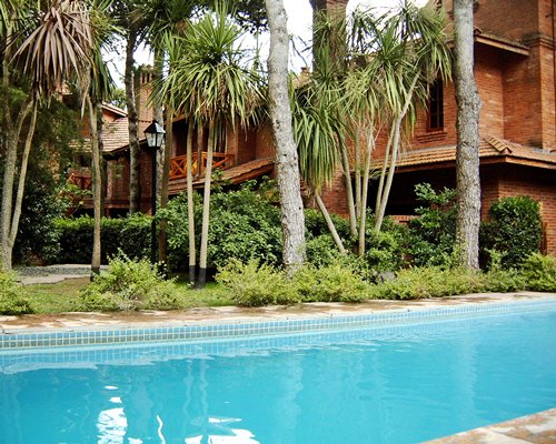An outdoor swimming pool alongside multi story resort units.