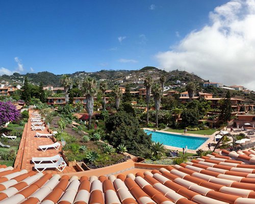An exterior view with outdoor pool and chaise lounge chairs.