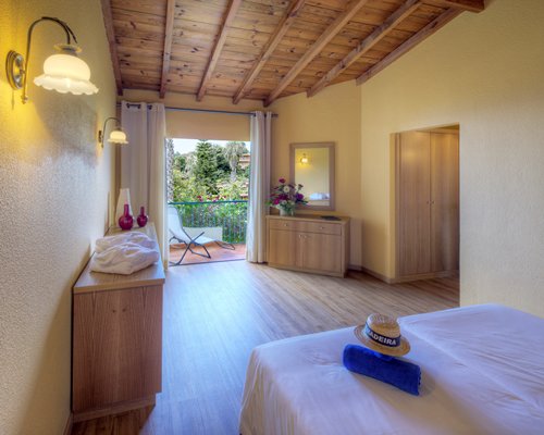 A bedroom view of bed with balcony and garden view.