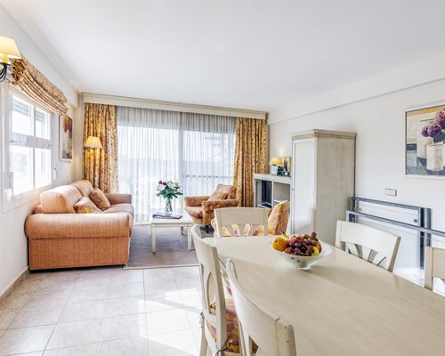 An open plan living and dining area with a television and an outside view.