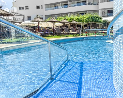 An outdoor swimming pool with chaise lounge chairs.
