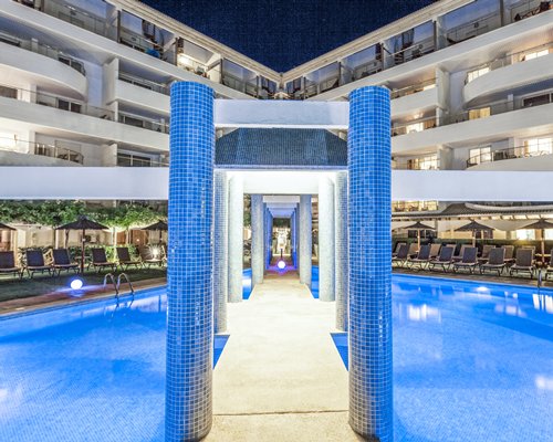 Pathway in between the outdoor swimming pool surrounded by multiple unit balconies.