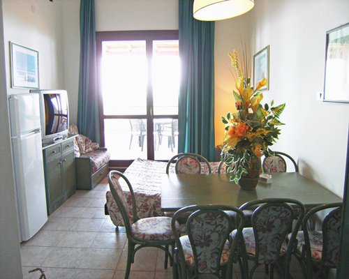 An open plan living and dining area with a television and patio.