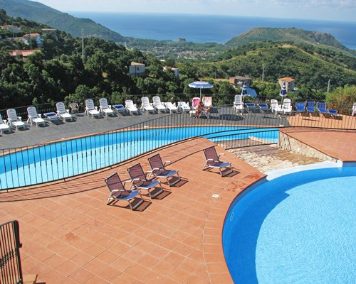 An outdoor swimming pool with chaise lounge chairs.