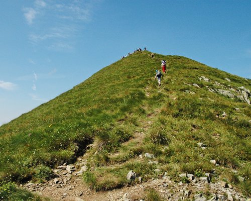 A view of people hiking on a hillock.