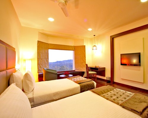 A well furnished bedroom with a television and an outside view.