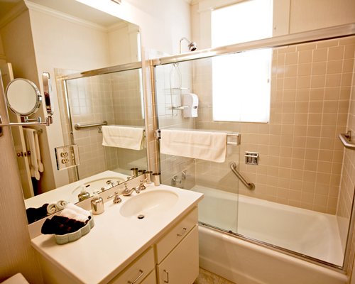 A bathroom with a shower bathtub and a single sink vanity.