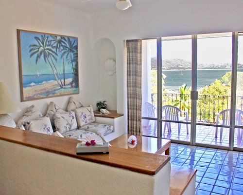 A well furnished living room with a balcony and ocean view.