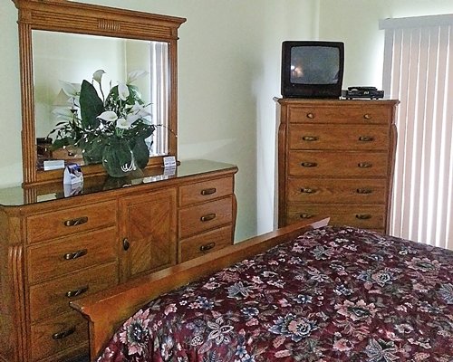 A well furnished bedroom with a television and dresser.