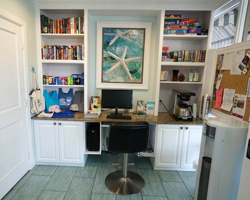 A common room with a computer mini library and coffeemaker.