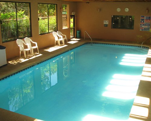 An indoor swimming pool with outside view.