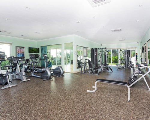A well equipped indoor fitness center with an outside view.