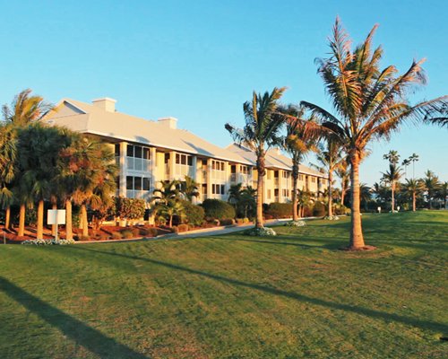 An exterior view of resort condos alongside a manicured lawn.