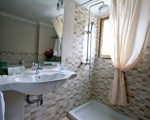 A bathroom with bathtub shower and a single sink vanity.