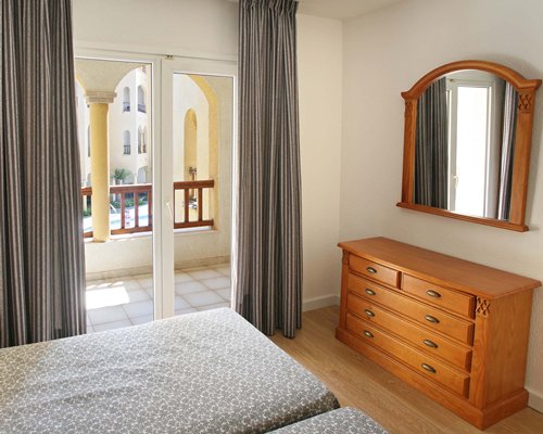 A well furnished bedroom with two twin beds and an outside view.