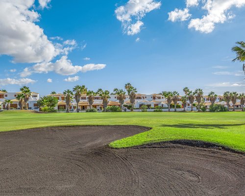A golf course putting green alongside resort.