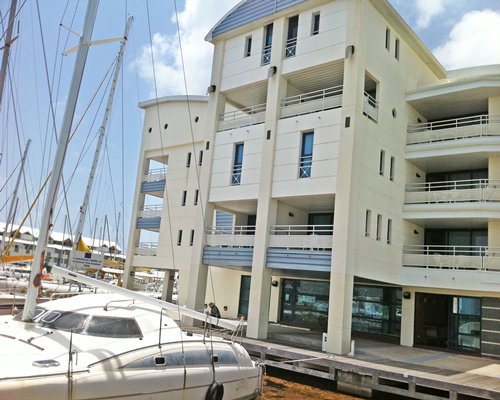 View of multiple unit balconies with boats in a marina.
