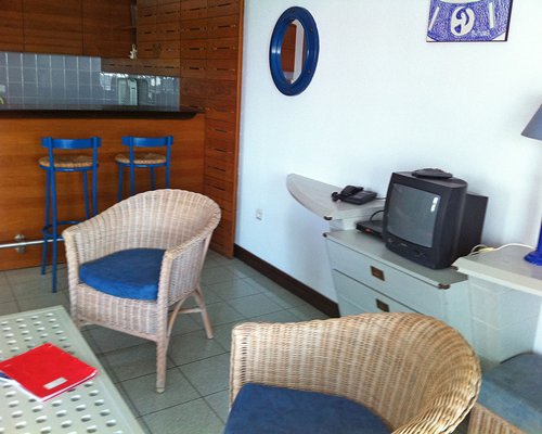 A furnished living room with a television and a breakfast bar.
