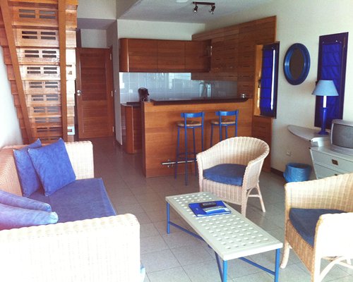 A well furnished living room with a breakfast bar and staircase.