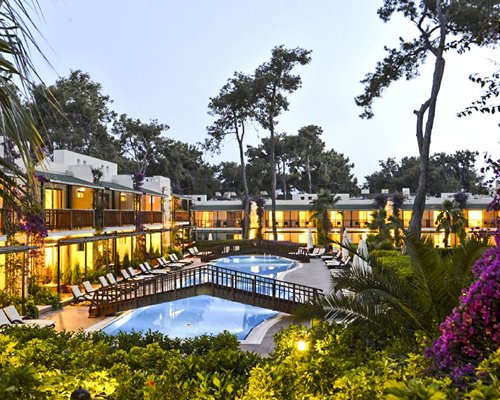 Scenic outdoor swimming pool with chaise lounge chairs alongside the resort.