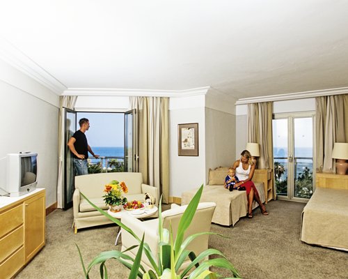 Family at a furnished unit with a bed couch television and sea view.