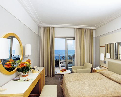 A well furnished bedroom with vanity and a balcony.