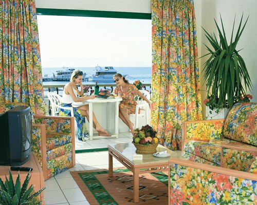 A well furnished living room with a television and a balcony.