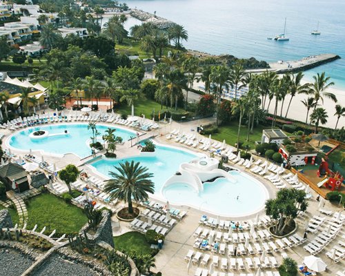 An aerial view of a large outdoor swimming pool with chaise lounge chairs.