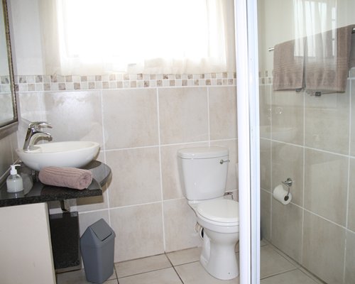 A bathroom with shower sink and vanity.