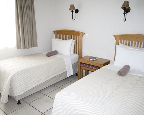 A well furnished bedroom with two twin beds.