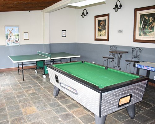 Indoor recreation room with pool table and ping pong.