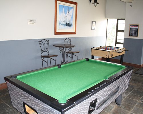 An indoor recreational room with pool table and foosball table.