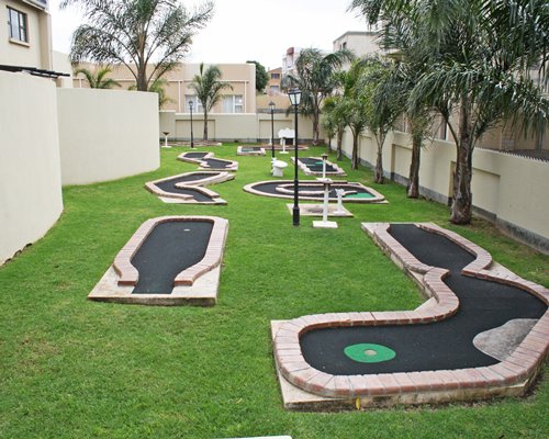 Outdoor recreation area with putt putt golf course and palm trees.