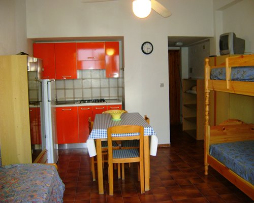 Furnished room with bunk beds and dining area.