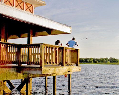 View of people fishing on a wooden pier.