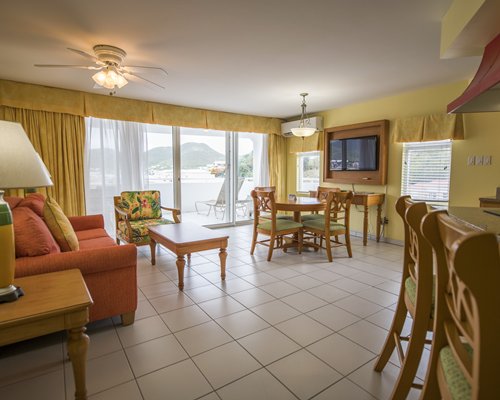 A living room with open plan dining area and balcony.