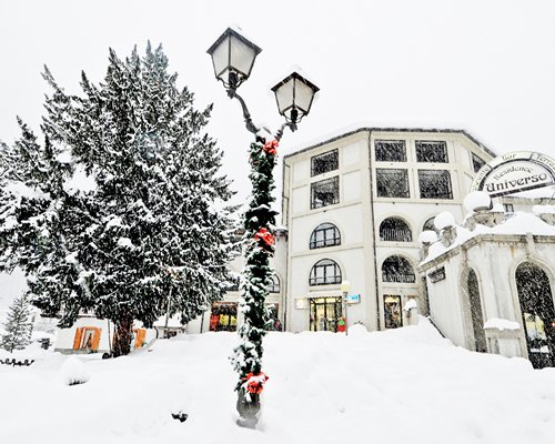 Exterior view of Residence Universo with outdoor lamp during winter.