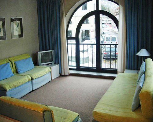 A well furnished living room with television and outdoor view.