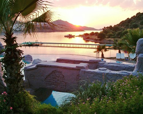 View of grotto pool and wooden pier on the sea at dusk.