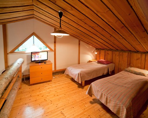 A wood paneled bedroom with beds and television.