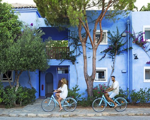 A group of people riding bicycles on a pathway alongside resort condos.