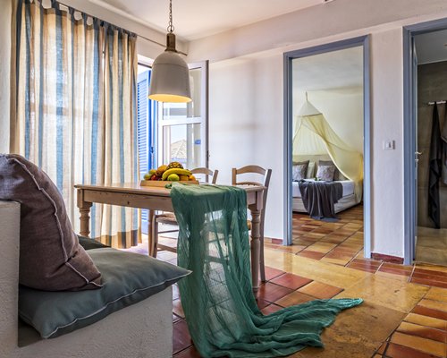An open plan living room and dining with a bedroom and an outside view.