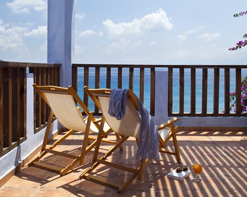 Balcony with chaise lounge chairs overlooking the water.