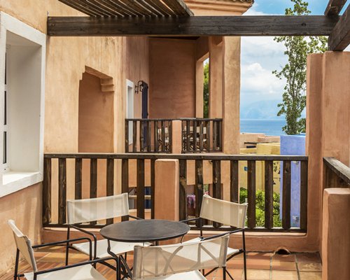 View of multiple balconies with patio furniture and beach view.